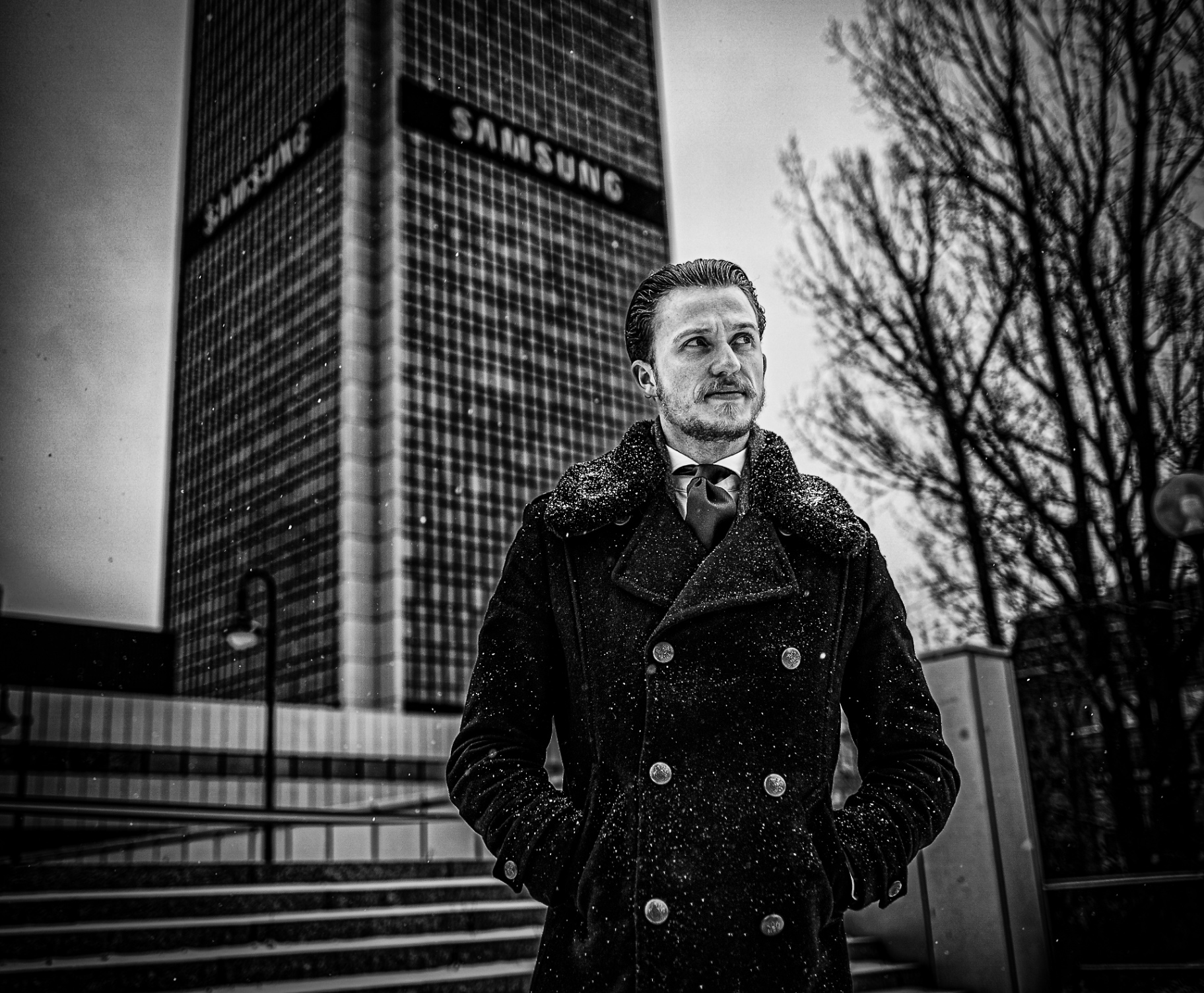 Czarno-biały portret mężczyzny w płaszczu zimą