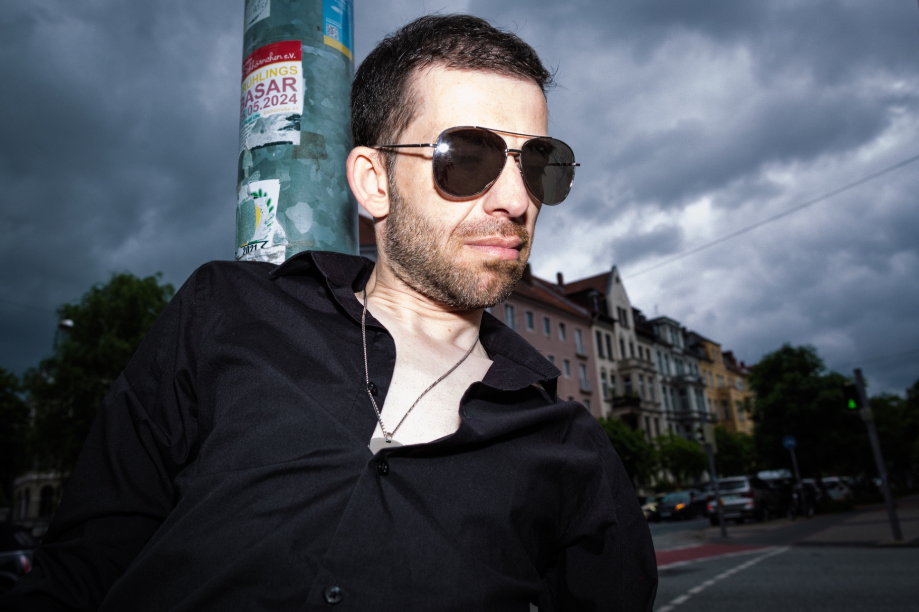Męski portret w okularach pod burzowym niebem